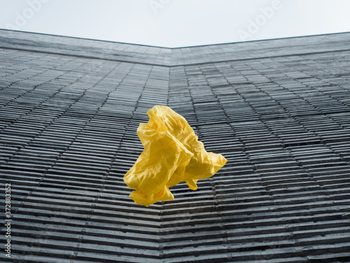 thrown yellow fabric in front of grey structured modern building photo