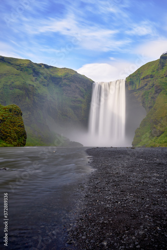 Perspective from the river of the beautiful landscape of the Skogafoss waterfall in Iceland