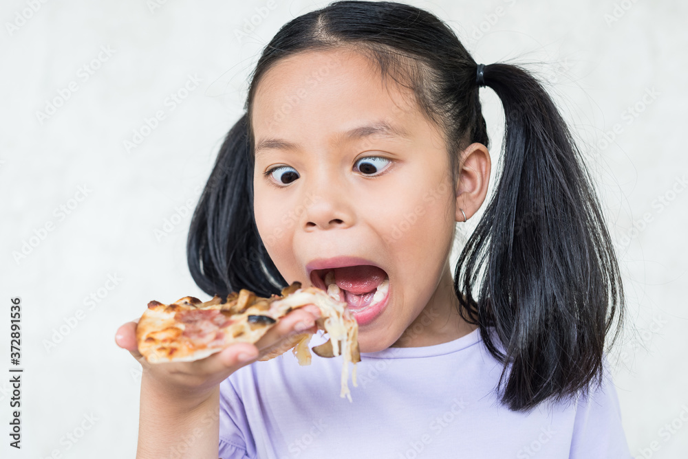 cute little girl holds piece of pizza, hungry student opens mouth wide while sees delicious slice of pizza, wants to eat, positive woman with junk food, people and eating, people and snack concept. cute little girl holds piece of pizza, hungry student opens mouth wide while sees delicious slice of pizza, wants to eat, positive woman with junk food, people and eating, people and snack concept.