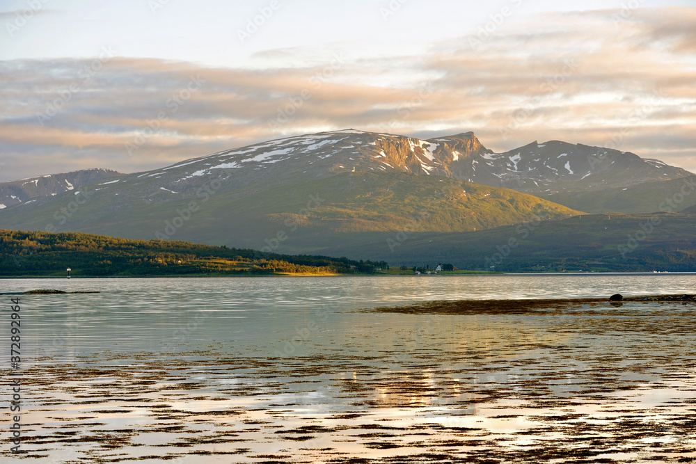 Northern landscape with sea and mountains. Midnight sun in Tromso, Norway