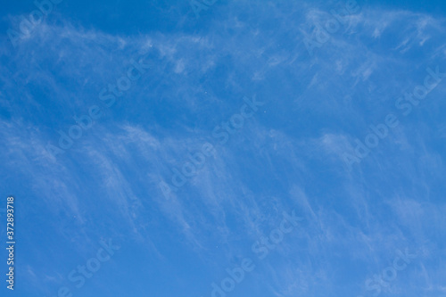 Blue sky with very spread contrails. These have almost disappeared.