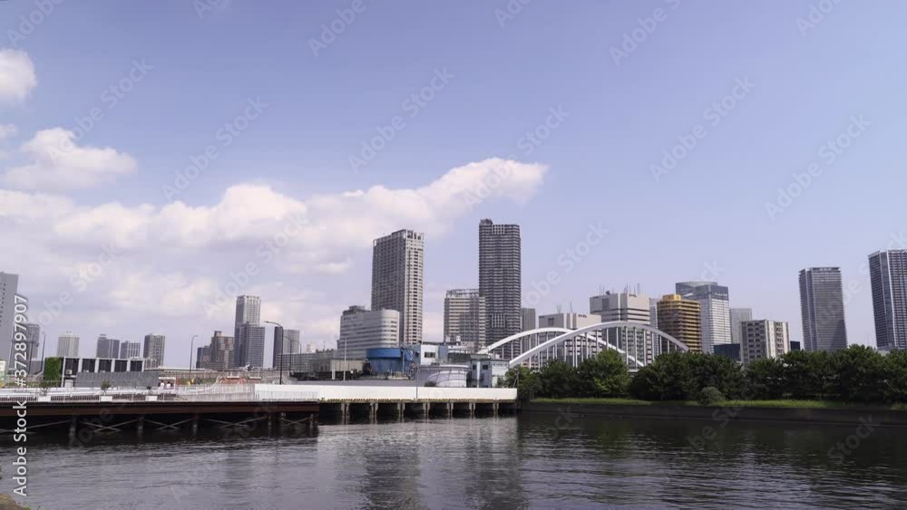 Sea Level view of Skyscrapers of Odaiba, Tokyo with blue sky and clouds Sea Level view of Skyscrapers of Odaiba, Tokyo with blue sky and clouds