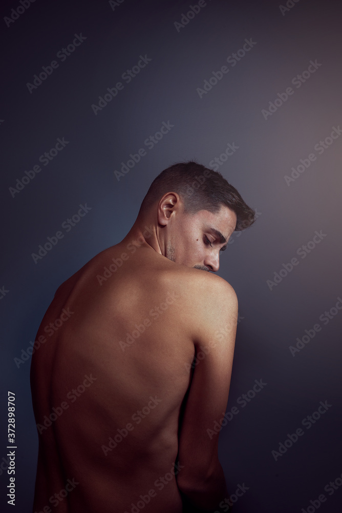 Contrite man facing away against a plain background Contrite man facing away against a plain background