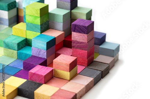 Spectrum of stacked multi-colored wooden blocks. Background or cover for something creative  diverse  expanding  rising or growing. On pure white.