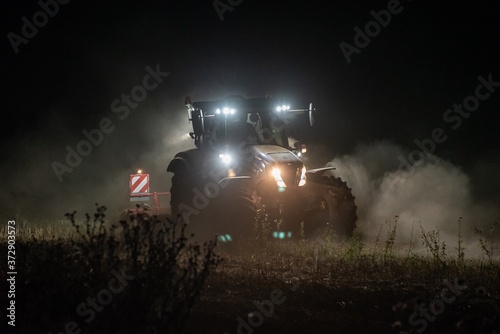 Traktor bestellt ein Feld in der Nacht