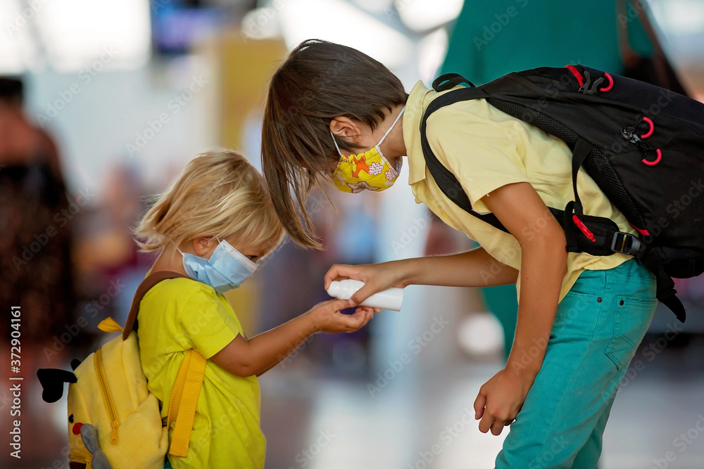 Mother and child, boy and mom, wearing masks and using disinfection