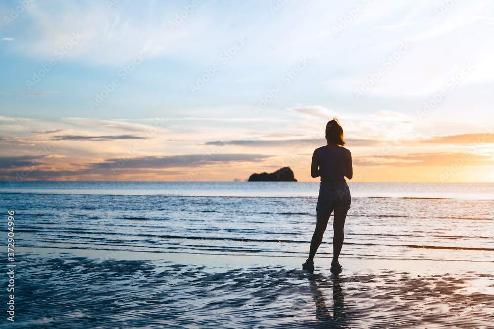 Rear view of young adult travel asian woman relax in nature on beach sea with morning sky