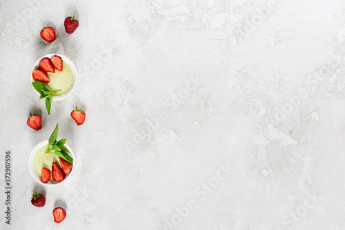Homemade avocado panna cotta with strawberries, mint and coconut. Sugar, lactose, gluten free. Healthy food, diet, vegetarian. Horizontal orientation, copy space, top view.