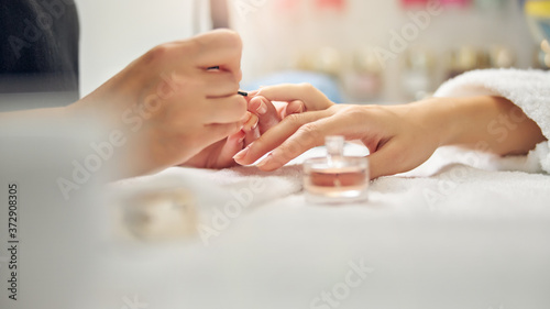 Woman doing nude manicure in beauty salon