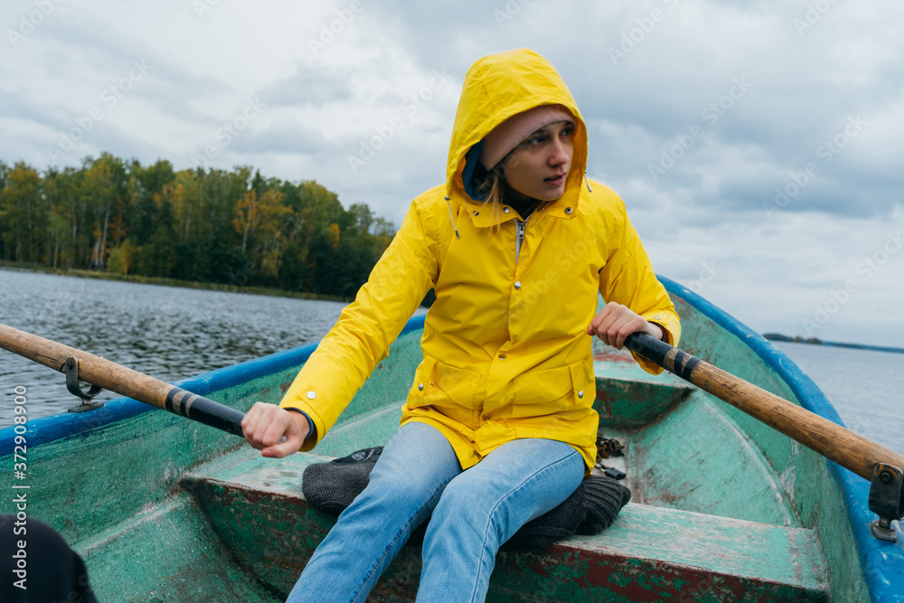 Woman rowing on oars on an autumn lake Woman rowing on oars on an autumn lake