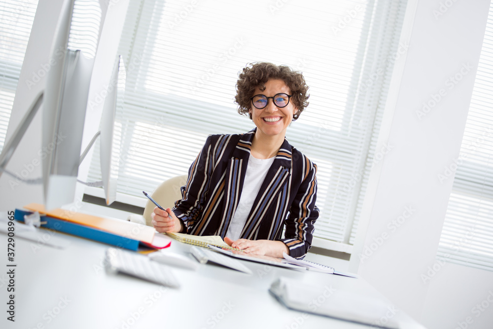 Portrait of a business woman at workplace in an office Portrait of a business woman at workplace in an office