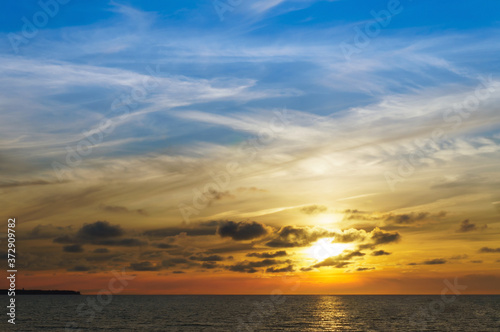 Sunset over the sea. Reflection of sunlight in the sea waves. The sky in the sunset rays.