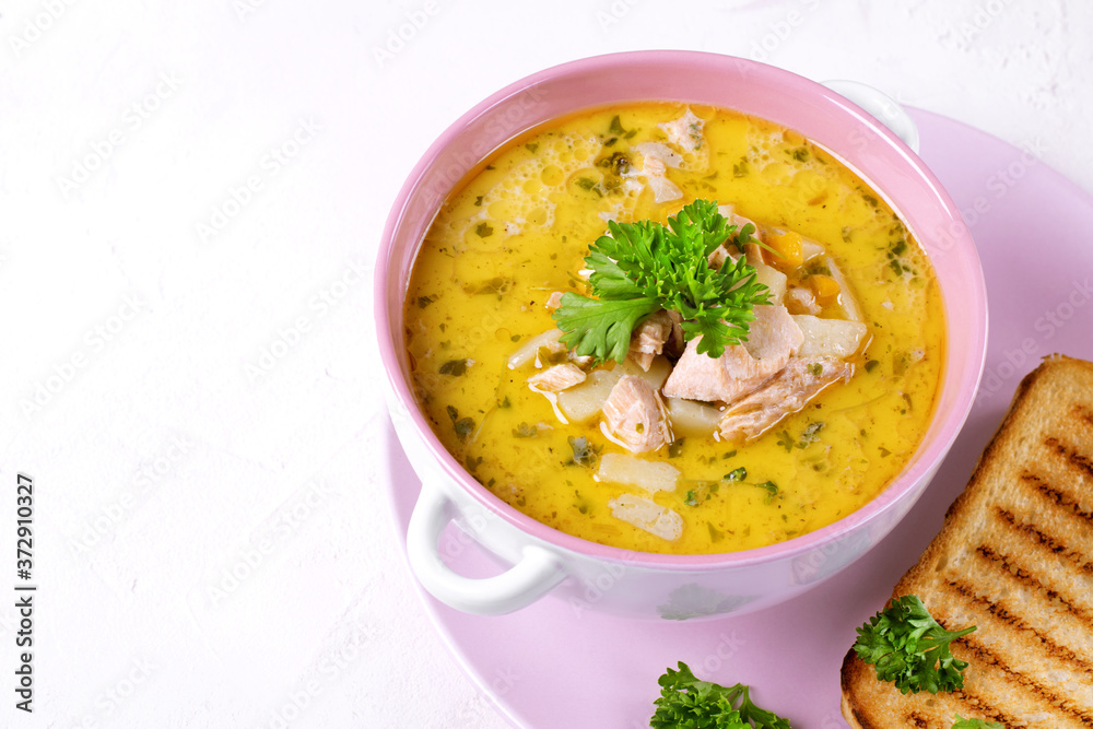 Soup with red fish and cream topped with fresh parsley served in a ceramic tureen. Asian cuisine hot meal Soup with red fish and cream topped with fresh parsley served in a ceramic tureen. Asian cuisine hot meal