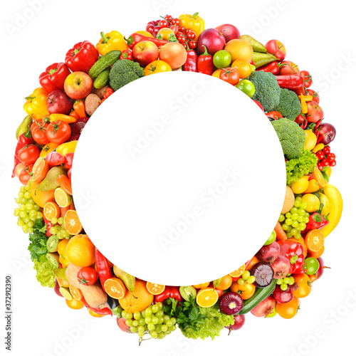 Round frame of bright and colorful fruits, vegetables and berries isolated on white