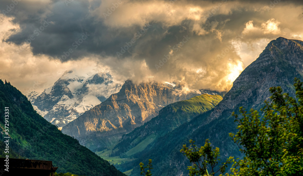 View of multicolor mountains against the sunset light in the swiss Alps