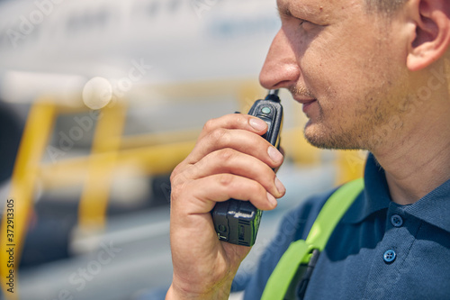 Man using a two-way radio transceiver outside