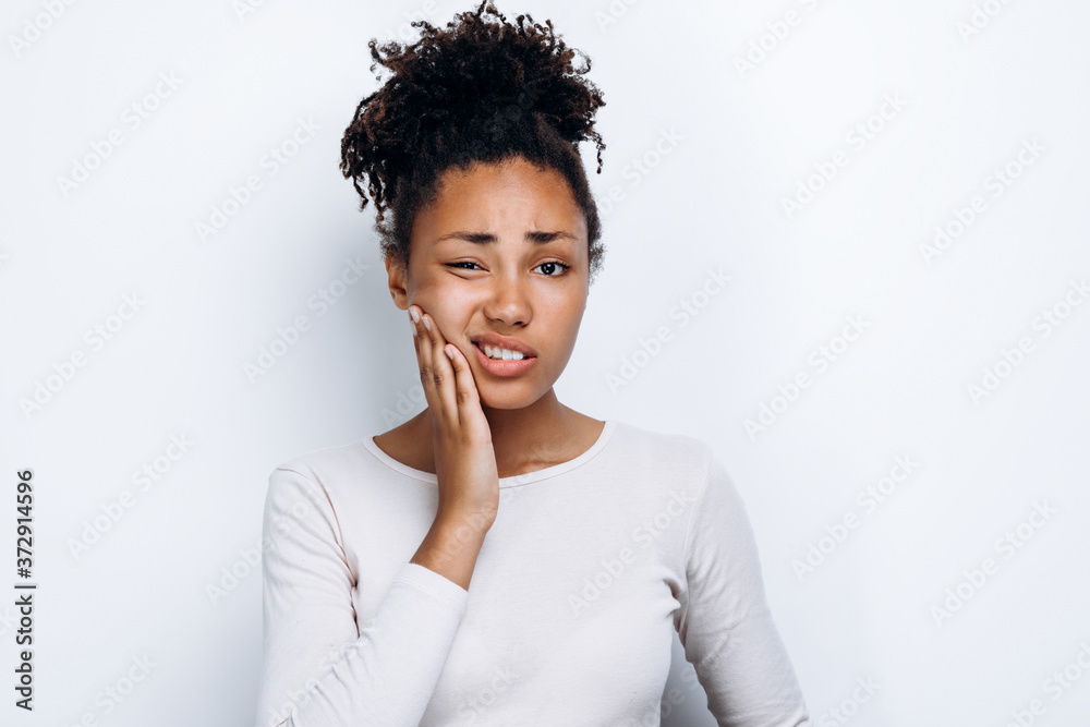African american girl standing over isolated white background touching mouth with hand with painful expression because of toothache African american girl standing over isolated white background touching mouth with hand with painful expression because of toothache