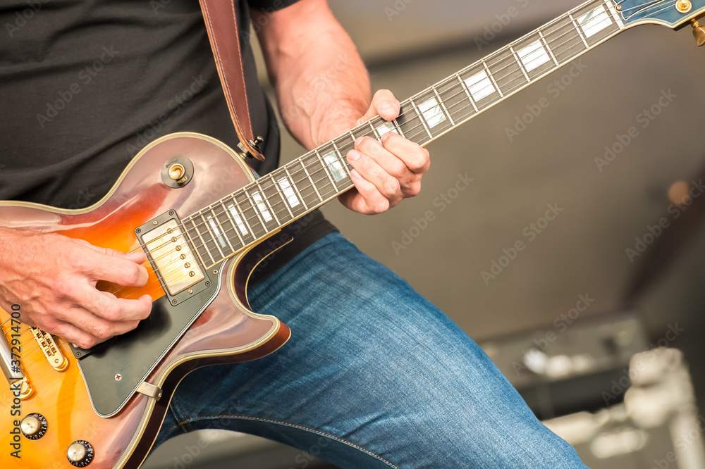 closeup of a musician strumming an electric guitar