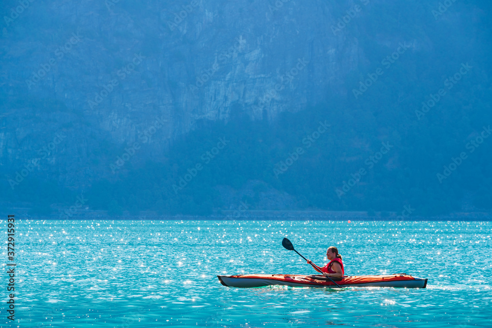 Woman sea kayaking in Norwegian fjord