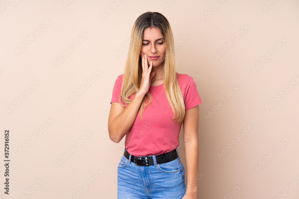 Young Uruguayan woman over isolated background with toothache Young Uruguayan woman over isolated background with toothache