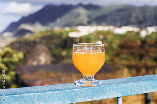 A glass of yellow drink - traditional alcoholic orange drink from Madeira - poncha