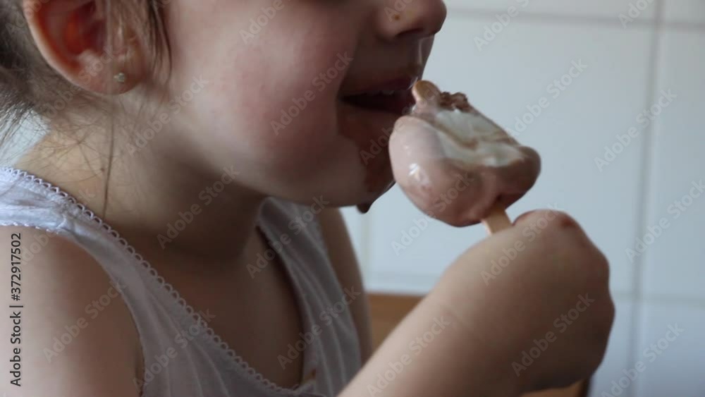 Niña comiendo un helado de chocolate