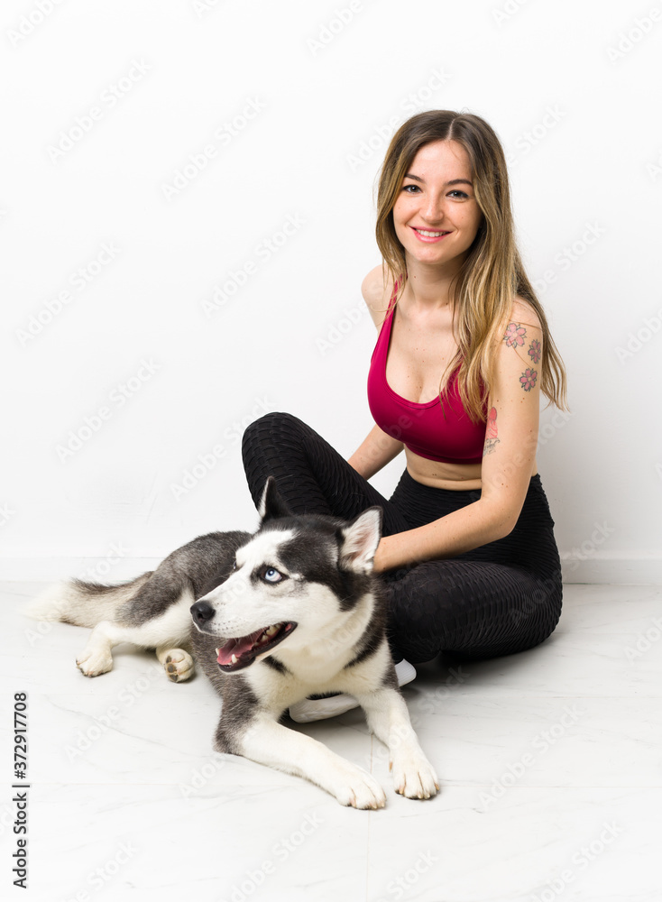 Young sport girl with her dog sitting on the floor