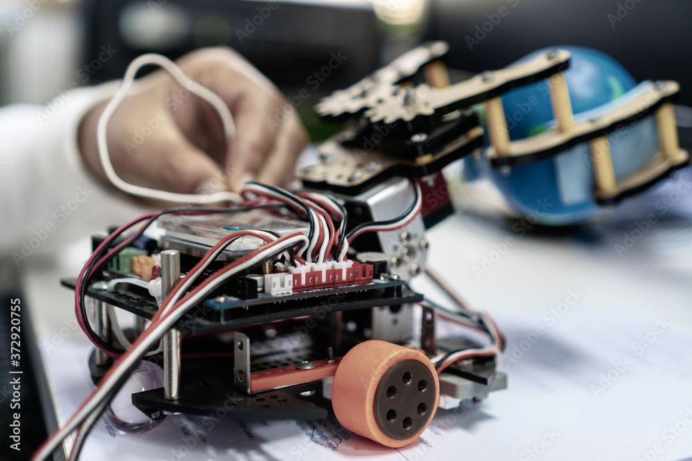 Obraz premium Robotics technology, STEM education lab learning coding study concept : Metal robot and electronic board robots with student learn Programing in computer laboratory at science classroom