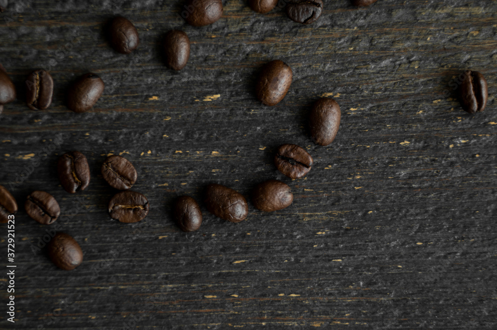 Roasted arabica coffee beans scattered on a wooden table. Fresh coffee beans. Roasted arabica coffee beans scattered on a wooden table. Fresh coffee beans.
