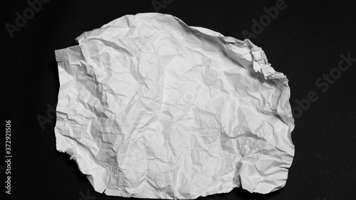 a crumpled white sheet of paper on a black background.
