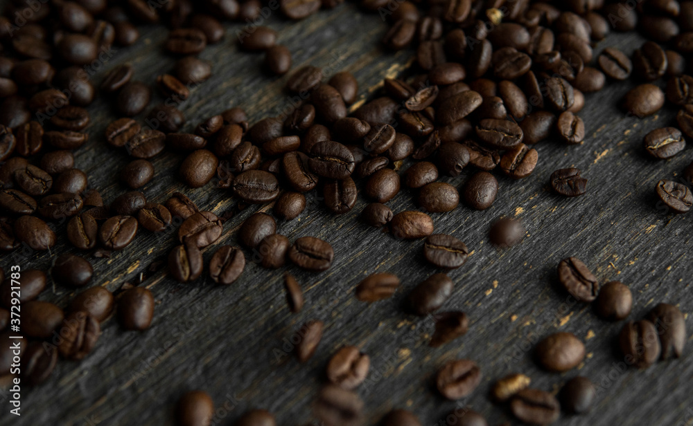 Roasted arabica coffee beans scattered on a wooden table. Fresh coffee beans. Roasted arabica coffee beans scattered on a wooden table. Fresh coffee beans.