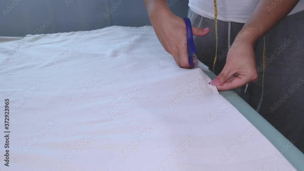 The cutter cuts the fabric with scissors.