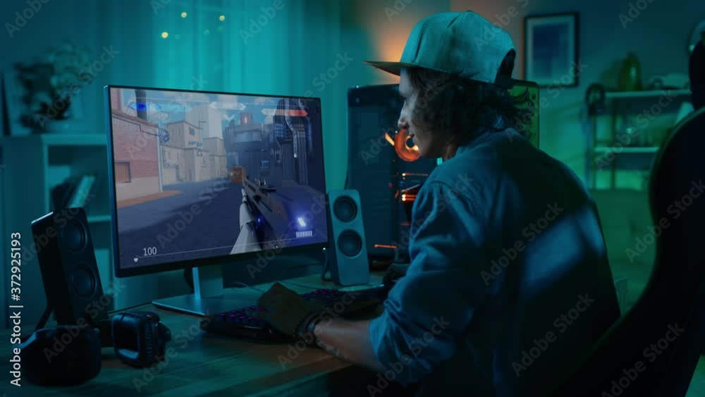 Professional eSports Gamer Plays 3D Shooter Mock-up Video Game with Lots of Action and Fun on His Powerful Personal Computer. Cyber Gaming Stylish Retro Neon Room Professional eSports Gamer Plays 3D Shooter Mock-up Video Game with Lots of Action and Fun on His Powerful Personal Computer. Cyber Gaming Stylish Retro Neon Room