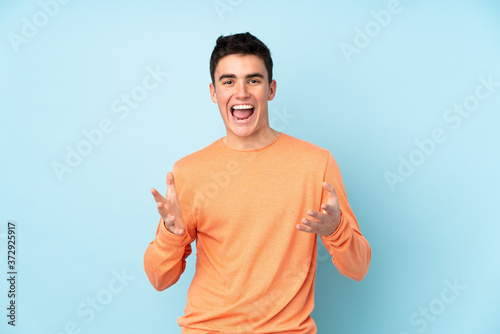 Teenager caucasian handsome man isolated on purple background unhappy and frustrated with something