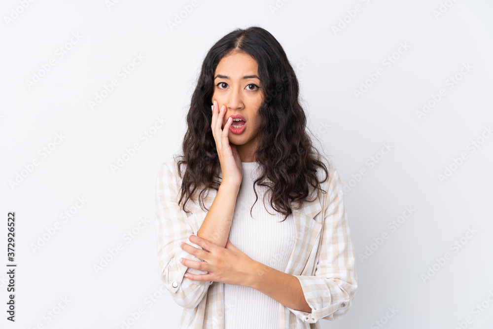 Mixed race woman over isolated white background surprised and shocked while looking right Mixed race woman over isolated white background surprised and shocked while looking right