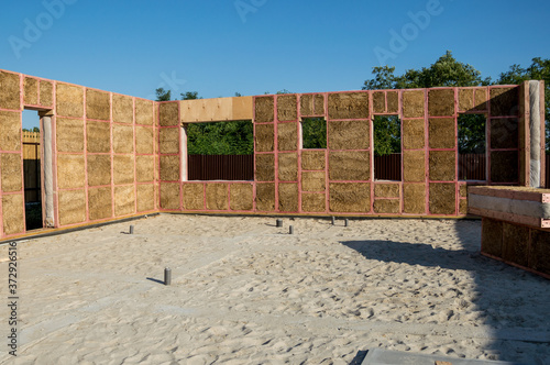 Construction of a house from an environmentally friendly material of plant origin. Frame made of wood, blocks of straw.