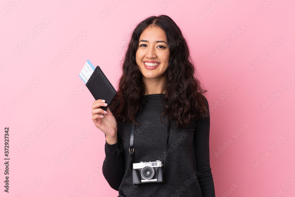 Mixed race woman over isolated pink background happy in vacation with passport and plane tickets Mixed race woman over isolated pink background happy in vacation with passport and plane tickets
