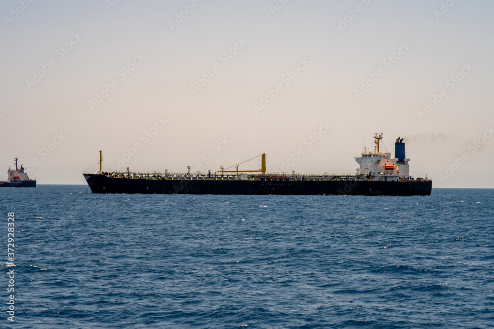 Large empty containter ship without cargo entering harbor in Port Sudan with a tugboat. Sudan, Red Sea.