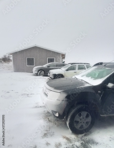 cars covered in snow and ice in a snowstorm in iceland
