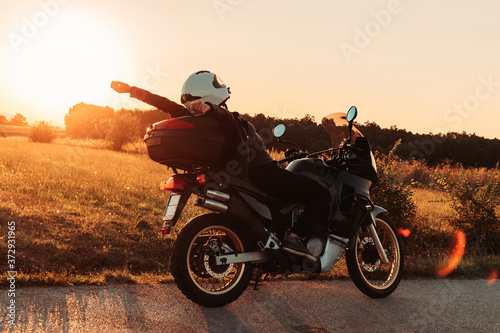 Female biker sitting on her bike, relaxing. Afternoon light, copy space