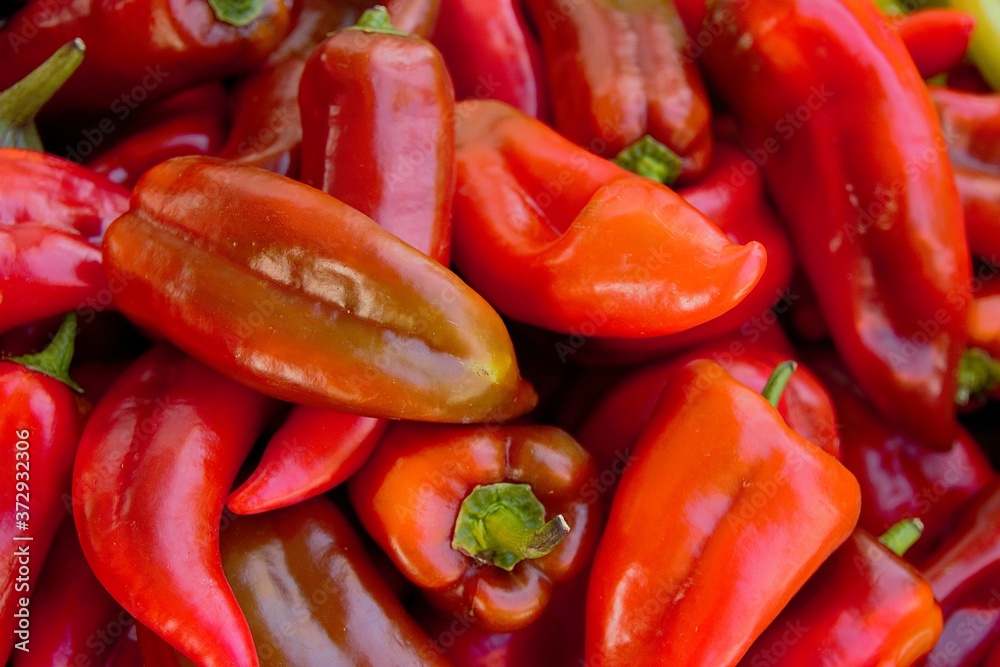 Pile of fresh red bell peppers on a grocery store, close up view

