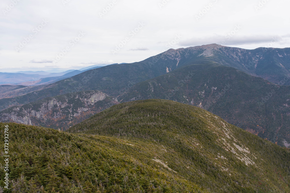 Mountain peaks and ranges in Maine and New Hampshire during the fall; leaves changing in the mountains