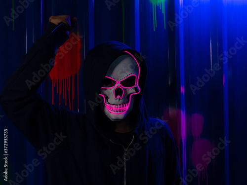 Unknown serial killer wearing neon skull mask with hoodie at Halloween  costume party with colorful background. Stock-foto | Adobe Stock