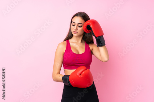 Young sport girl over isolated pink background with boxing gloves