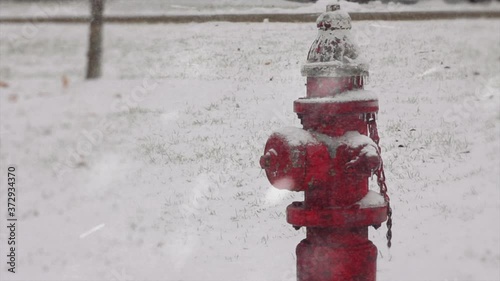 Snow covered red fire hydrant during a snow storm or blizzard