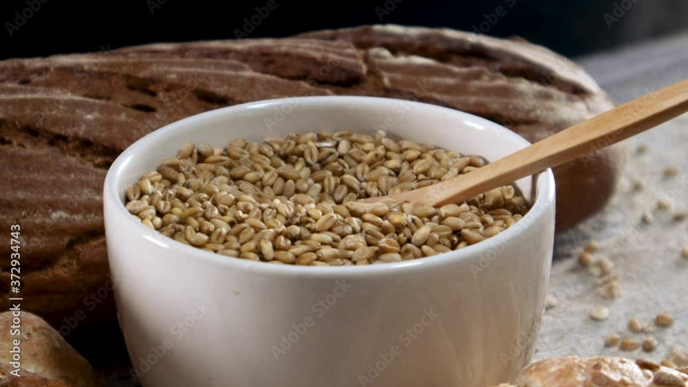 Putting wooden eco friendly spoon in bowl with organic grain Putting wooden eco friendly spoon in bowl with organic grain