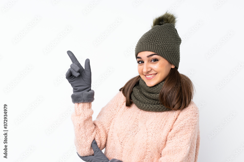 Young girl with winter hat over isolated white background pointing finger to the side Young girl with winter hat over isolated white background pointing finger to the side