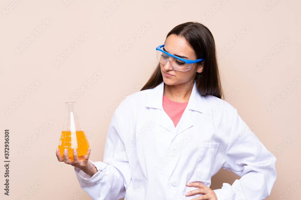 Young woman over isolated background with a scientific test tube Young woman over isolated background with a scientific test tube