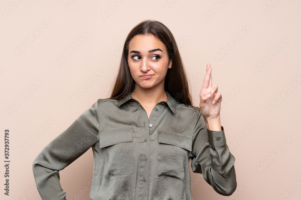 Young girl over isolated background with fingers crossing and wishing the best Young girl over isolated background with fingers crossing and wishing the best