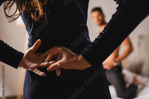 Foto Selective focus of woman with hands behind back taking off wedding ring near shi